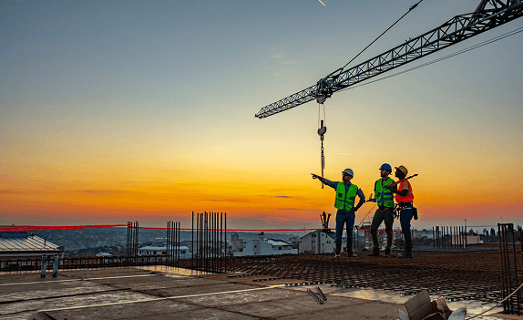 Construction workers at sunset